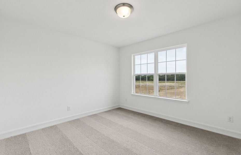 Comfortable secondary bedroom with generous closet space  *Real home pictured