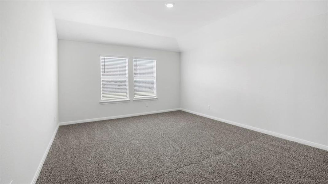 Unfurnished room with dark colored carpet and baseboards