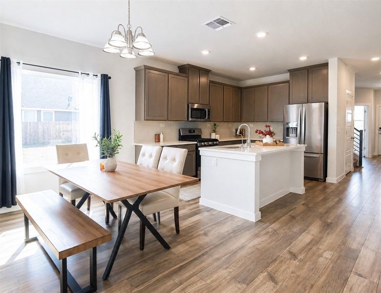 Rich wood-look flooring anchors this modern open space seamlessly connecting cooking and dining areas. Rich wood-look flooring anchors this modern open space seamlessly connecting cooking and dining areas.