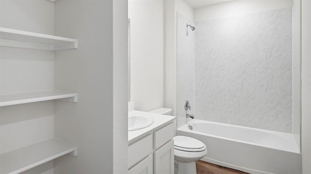 Bathroom with vanity, tub / shower combination, and dark wood-style floors Bathroom with vanity, tub / shower combination, and dark wood-style floors