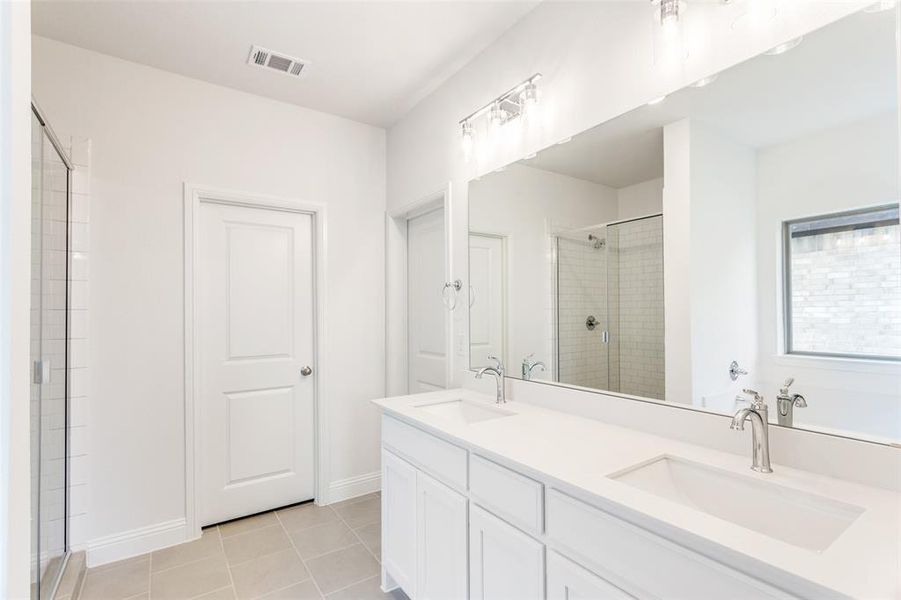 Bathroom with walk in shower, tile patterned flooring, and dual bowl vanity