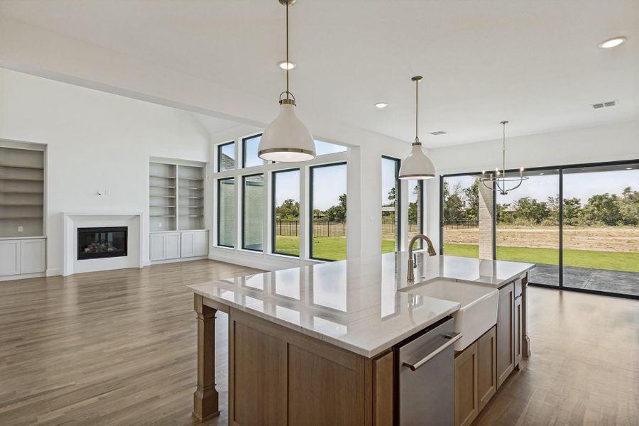 Gleaming hardwood floors and a spacious island anchor this light-filled open-concept living area.