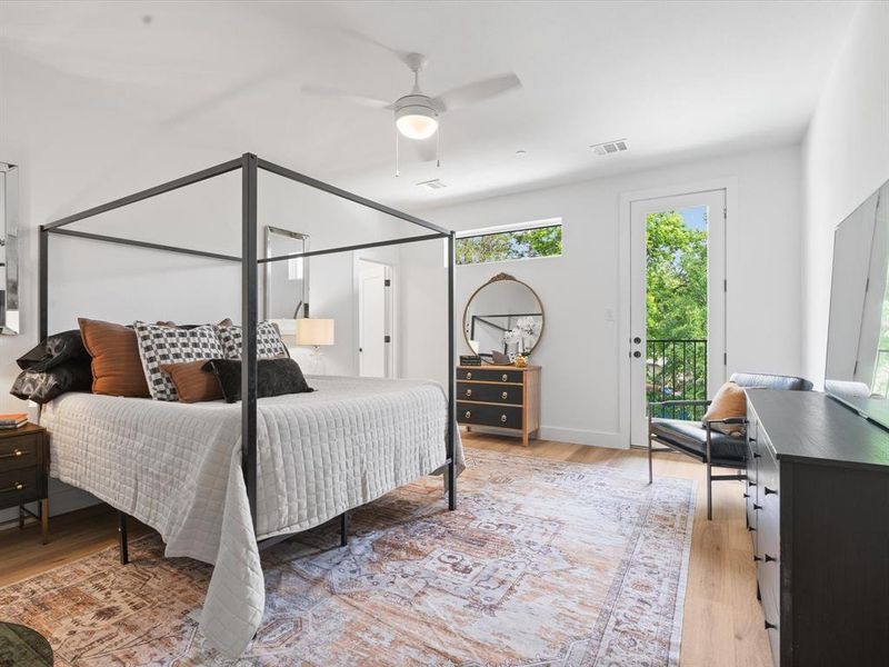 Bedroom featuring access to outside, a ceiling fan, light wood-style flooring, and visible vents Bedroom featuring access to outside, a ceiling fan, light wood-style flooring, and visible vents