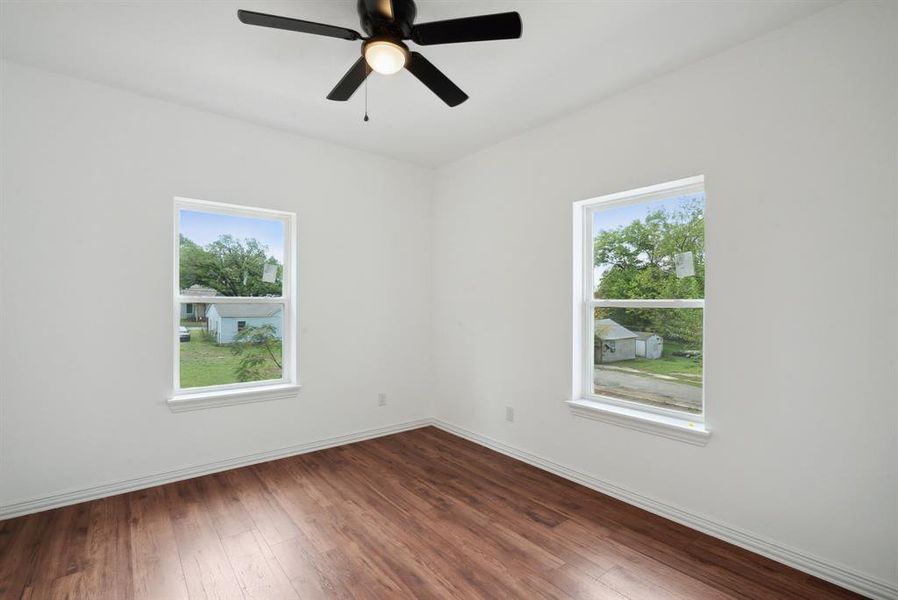 Empty room with wood-type flooring and ceiling fan