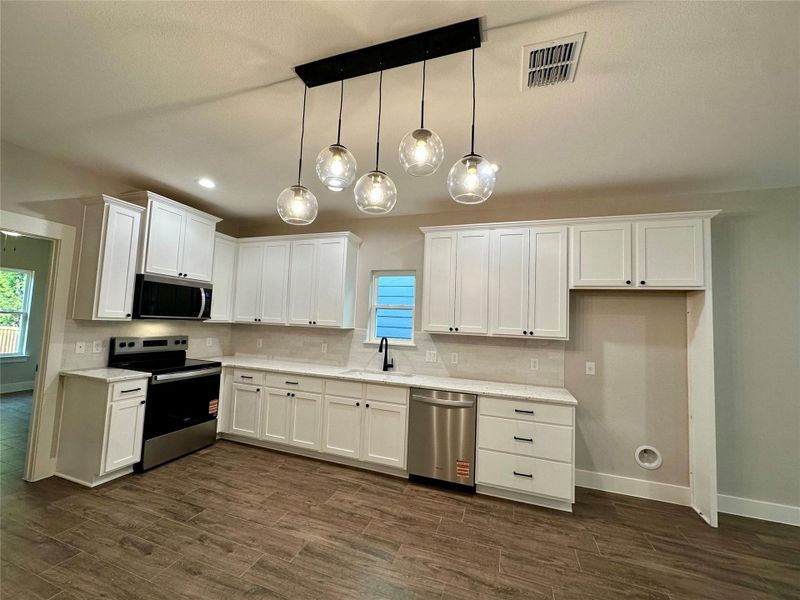 Kitchen featuring stainless steel appliances, white cabinetry, healthy amount of natural light, and recessed lighting