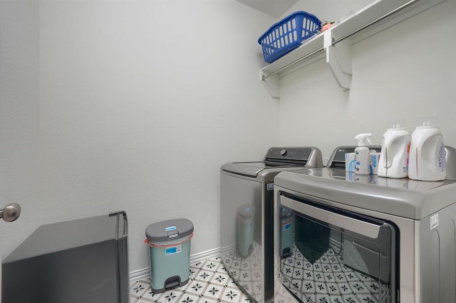 Washroom featuring independent washer and dryer and light tile flooring