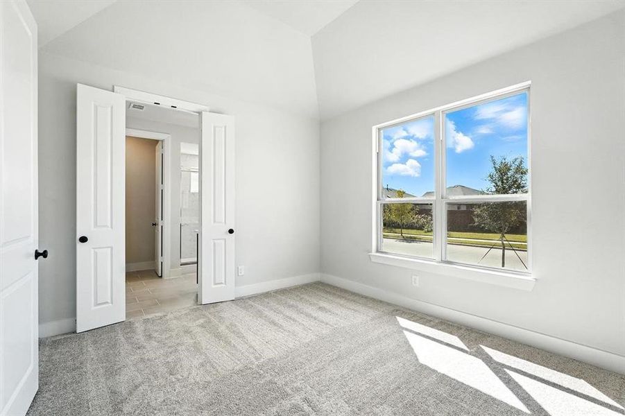 Unfurnished bedroom featuring light colored carpet, connected bathroom, and vaulted ceiling Unfurnished bedroom featuring light colored carpet, connected bathroom, and vaulted ceiling