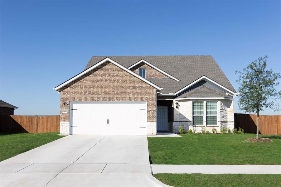 View of front facade with a garage and a front lawn