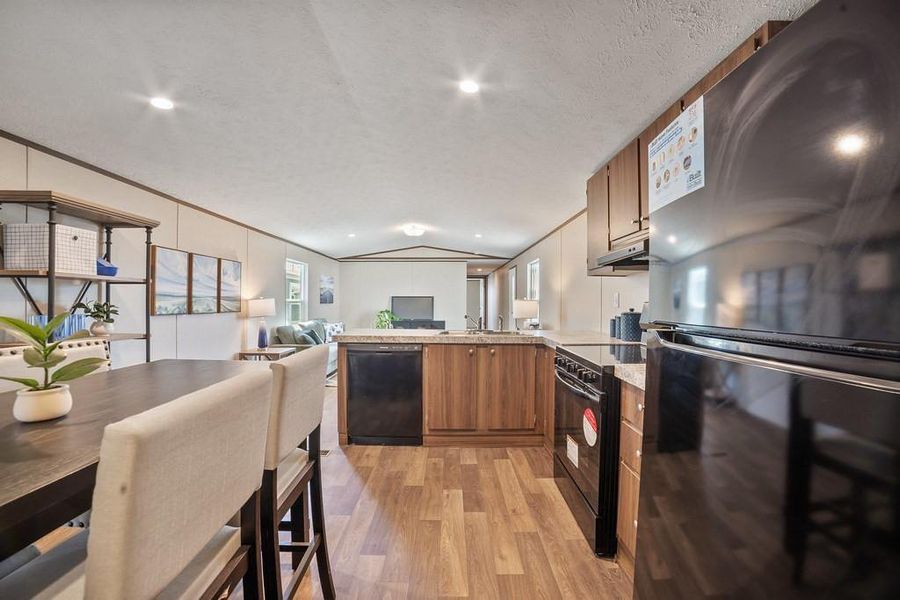 Kitchen with a peninsula, black appliances, open floor plan