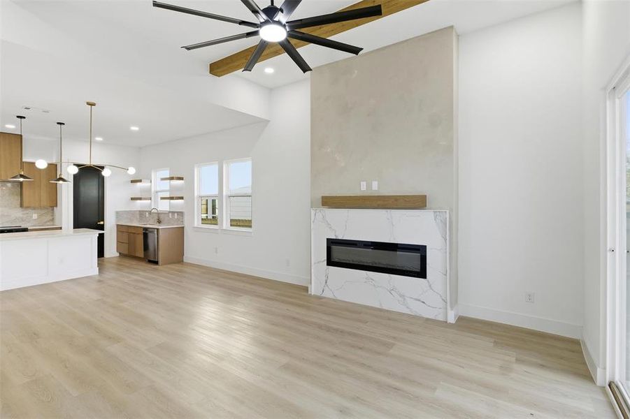 Unfurnished living room with a ceiling fan, light wood finished floors, a premium fireplace, and recessed lighting