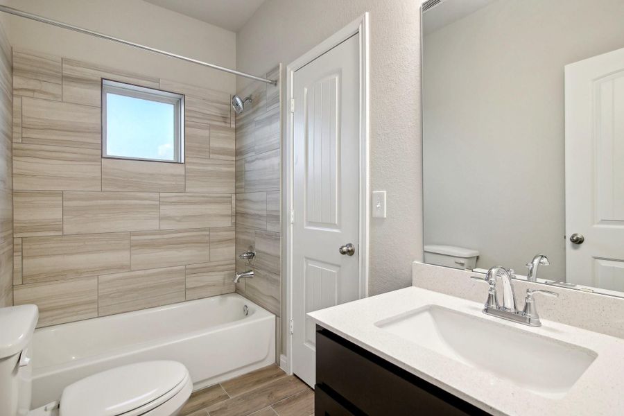 Step into the bathroom, it has a shower/tub combination and a gorgeous vanity mirror.