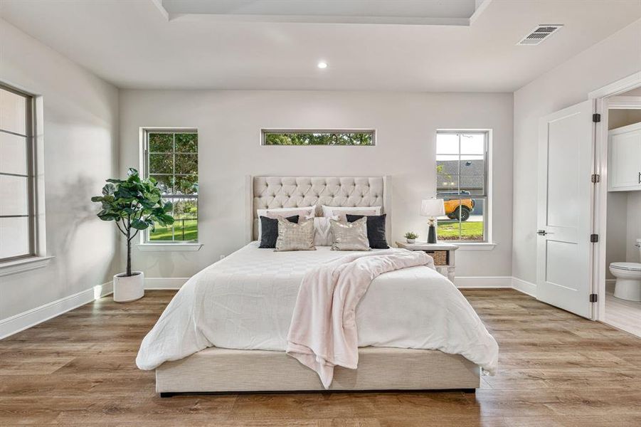 Bedroom with light wood-type flooring and ensuite bath