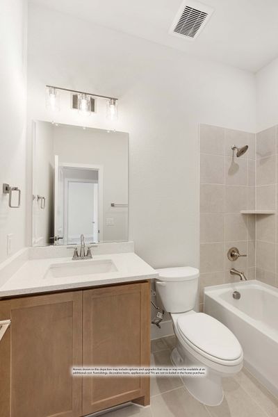 Bathroom with wood vanity, large mirror, toilet, and tiled bathtub-shower combo with neutral tile floors Bathroom with wood vanity, large mirror, toilet, and tiled bathtub-shower combo with neutral tile floors