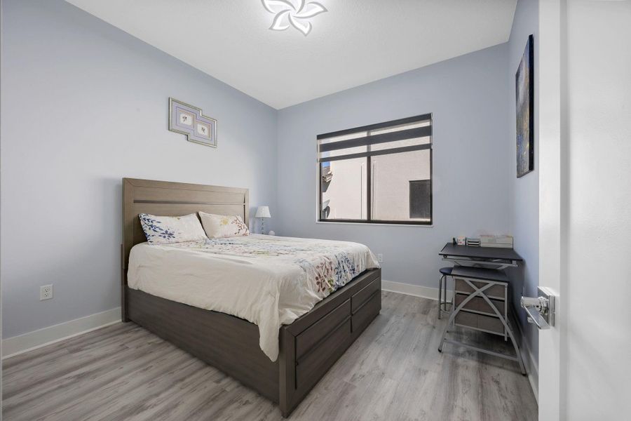 Bedroom with light wood-type flooring and baseboards
