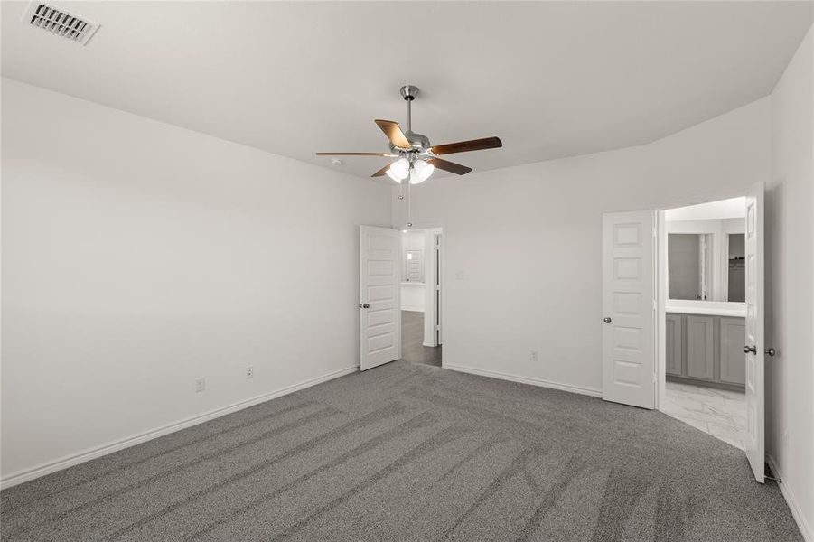 Unfurnished bedroom featuring ceiling fan, light colored carpet, and connected bathroom