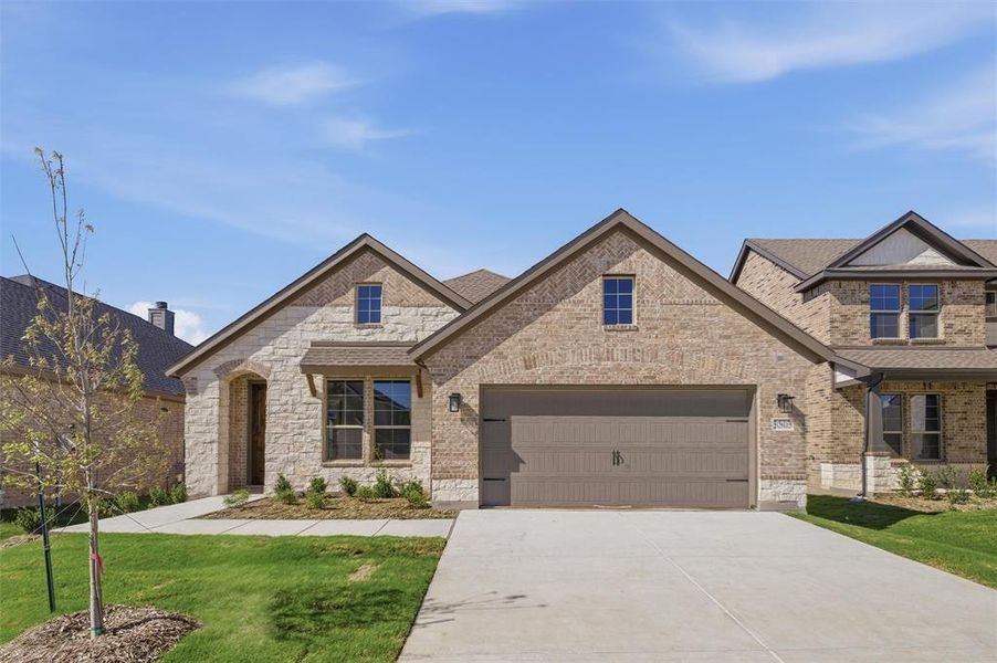 View of front of home featuring brick siding, concrete driveway, a garage, and a front lawn