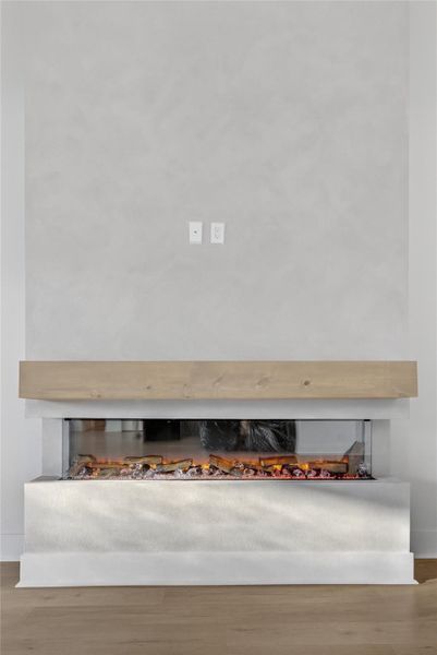 Spacious living room features a sleek linear fireplace with a wood mantel and a clean contemporary design. **Images are from a previously completed project. **