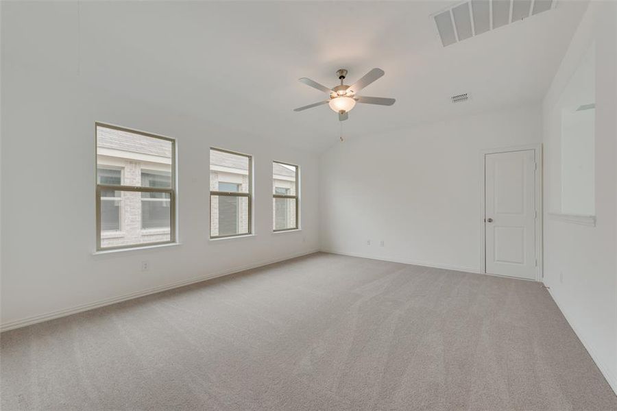 Carpeted spare room featuring ceiling fan