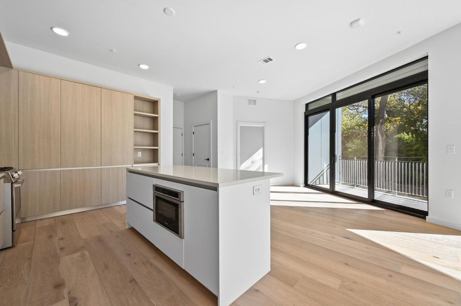 Kitchen with open shelves, light wood-style flooring, a kitchen island, modern cabinets, and recessed lighting Kitchen with open shelves, light wood-style flooring, a kitchen island, modern cabinets, and recessed lighting