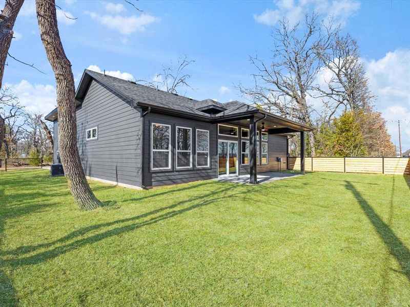 Back of property featuring a patio area, a fenced backyard, and roof with shingles