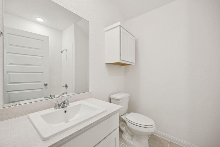 Full bath featuring a shower, vanity, and tile patterned flooring