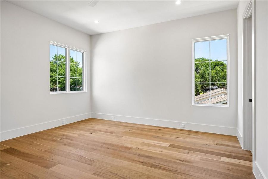 Secondary bedroom, hardwood floors, multi-window views, ceiling fan Secondary bedroom, hardwood floors, multi-window views, ceiling fan