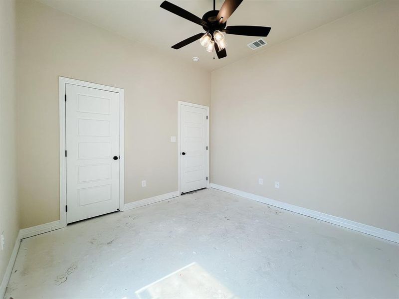 Unfurnished bedroom featuring concrete floors, ceiling fan, and a closet Unfurnished bedroom featuring concrete floors, ceiling fan, and a closet