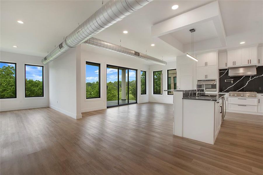 Kitchen featuring appliances with stainless steel finishes, plenty of natural light, white cabinets, and wood-type flooring