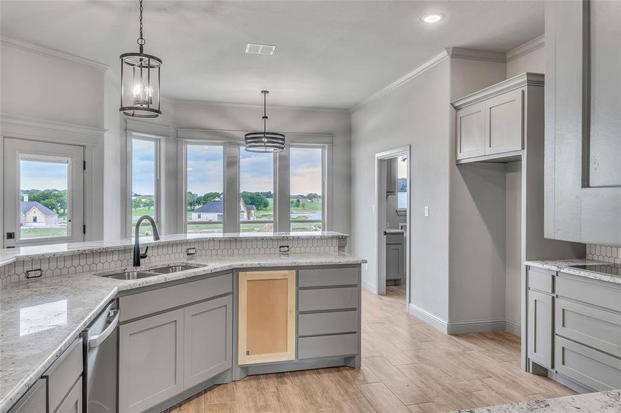 Kitchen with a notable chandelier, gray cabinets, decorative light fixtures, and sink