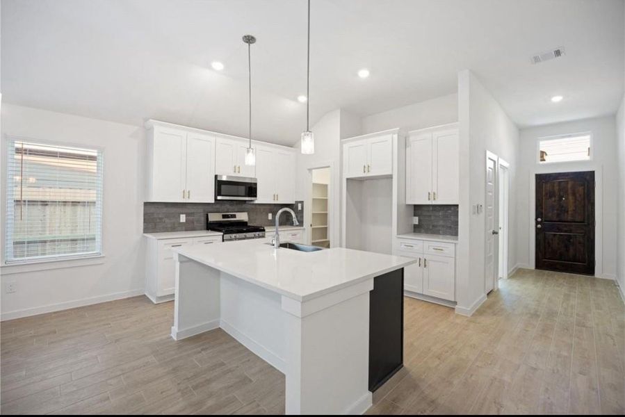 Beautiful open concept kitchen features soft close cabinets, plenty of LED lighting, stainless steel gas range, dishwasher, microwave included, high ceilings, beautiful pendant lighting and beautiful farmhouse sink options!