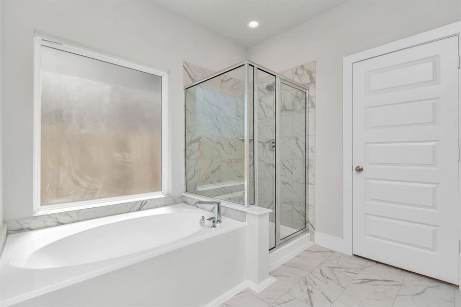 The primary en-suite has a soaking tub to give you that spa experience. The large privacy window allow lots of nature light in the space.