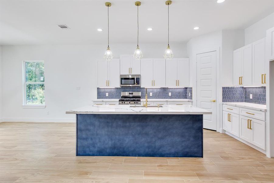 This kitchen is truly the heart of the home. With its sleek navy island and stunning gold fixtures, it’s not just a place to cook—it’s a place to create.