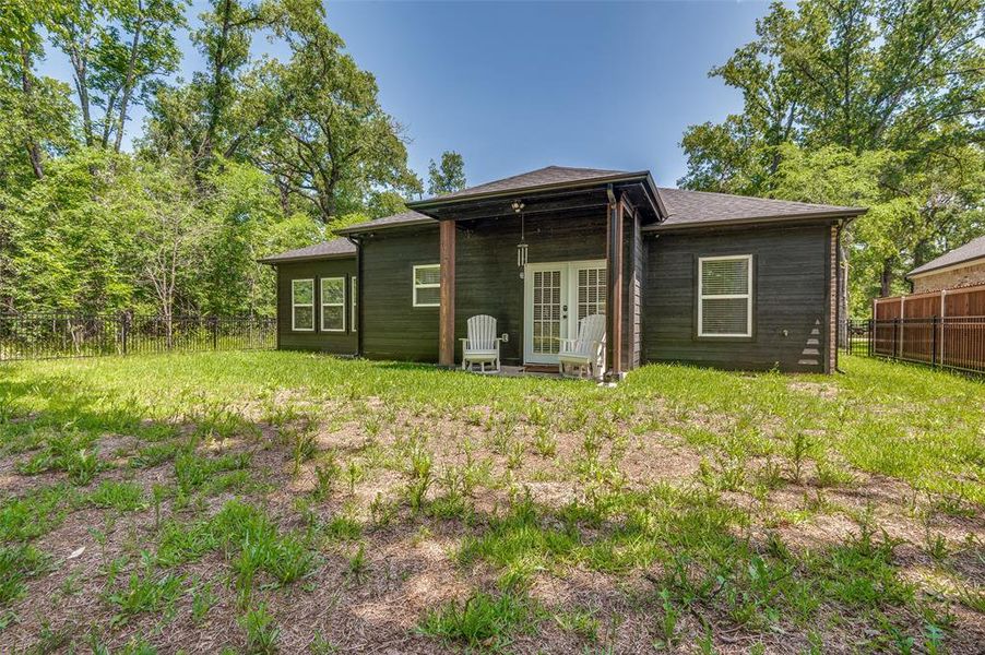 Rear view of house featuring a fenced backyard and french doors Rear view of house featuring a fenced backyard and french doors
