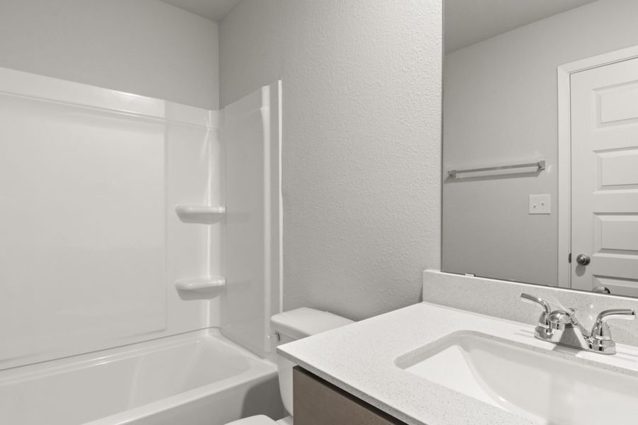 Image of a bathroom with a white vanity, a white shower and tub and a mirror