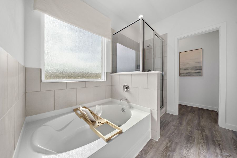 A bathroom with a tub sink and a mirror.