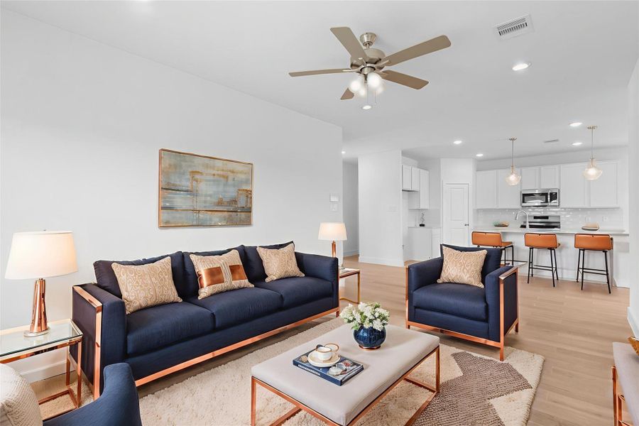 Spacious open living area with wood-look large plank tile flooring and seamless flow into the gourmet kitchen and dining spaces—perfect for entertaining. *Virtually Staged*