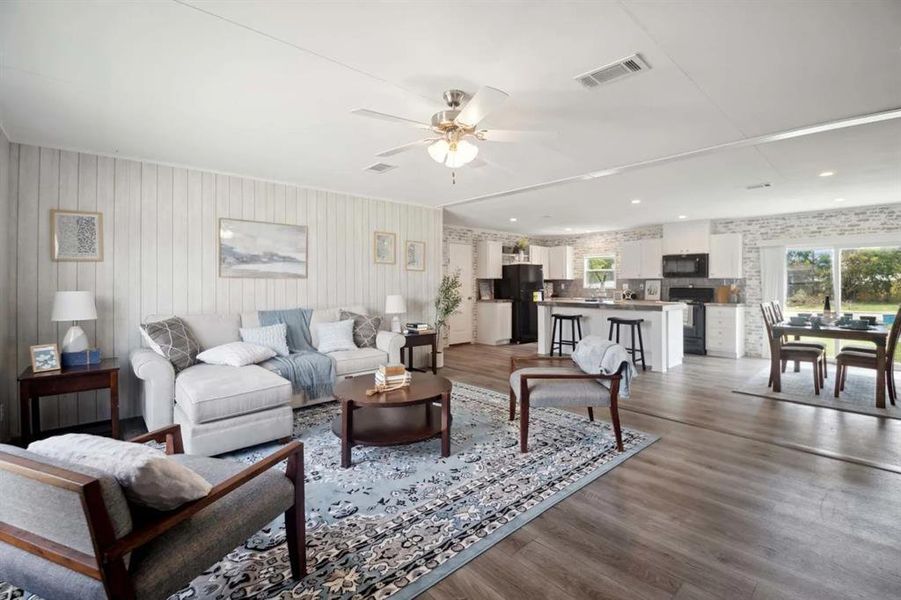 Living room with ceiling fan, a healthy amount of sunlight, and hardwood / wood-style flooring