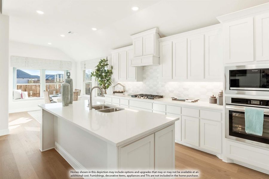 White kitchen with large center island, stainless steel appliances, and hardwood floors open to living area