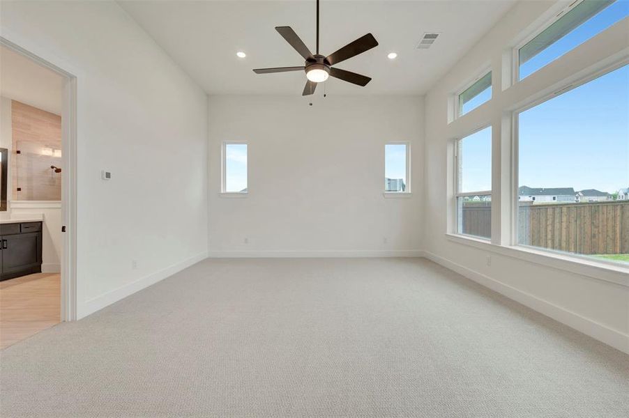 Owners Retreat featuring light carpet, ceiling fan, and recessed lighting