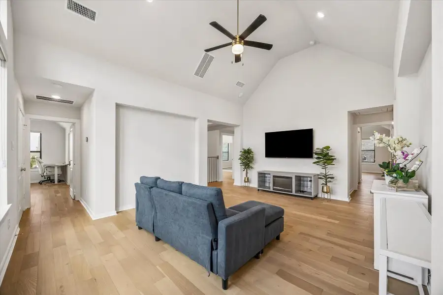 UPSTAIRS GAME ROOM FEATURES A VAULTED CEILING, CEILING FAN, WOOD FLOORING, AND OPEN ACCESS TO MULTIPLE SECONDARY ROOMS. UPSTAIRS GAME ROOM FEATURES A VAULTED CEILING, CEILING FAN, WOOD FLOORING, AND OPEN ACCESS TO MULTIPLE SECONDARY ROOMS.