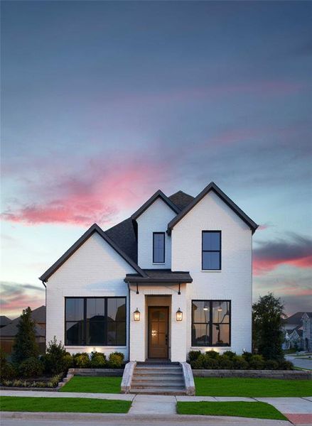 Modern farmhouse with brick siding and a lawn