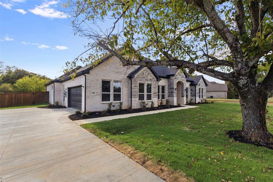 View of front of property with driveway, brick siding, and an attached garage