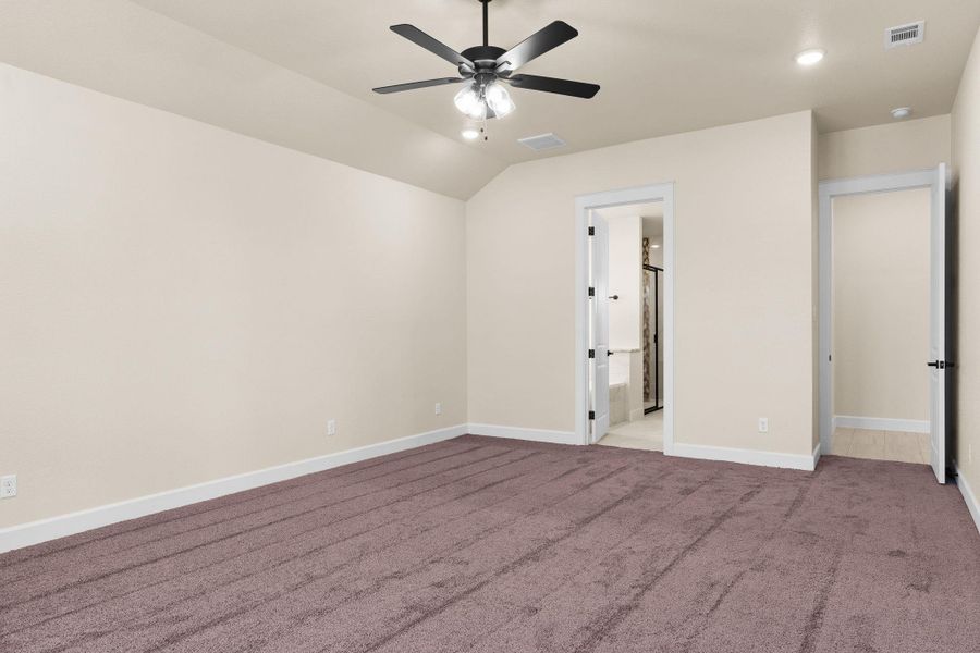 Unfurnished bedroom with carpet flooring, lofted ceiling, recessed lighting, a ceiling fan, and connected bathroom Unfurnished bedroom with carpet flooring, lofted ceiling, recessed lighting, a ceiling fan, and connected bathroom