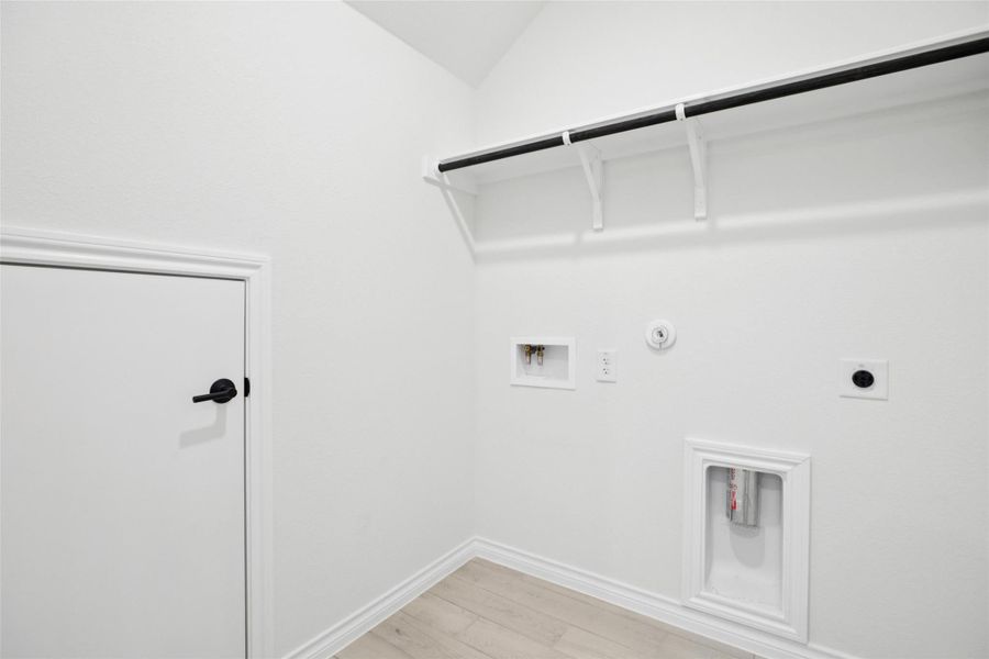 Washroom featuring hookup for a gas dryer, light wood-type flooring, electric dryer hookup, and hookup for a washing machine