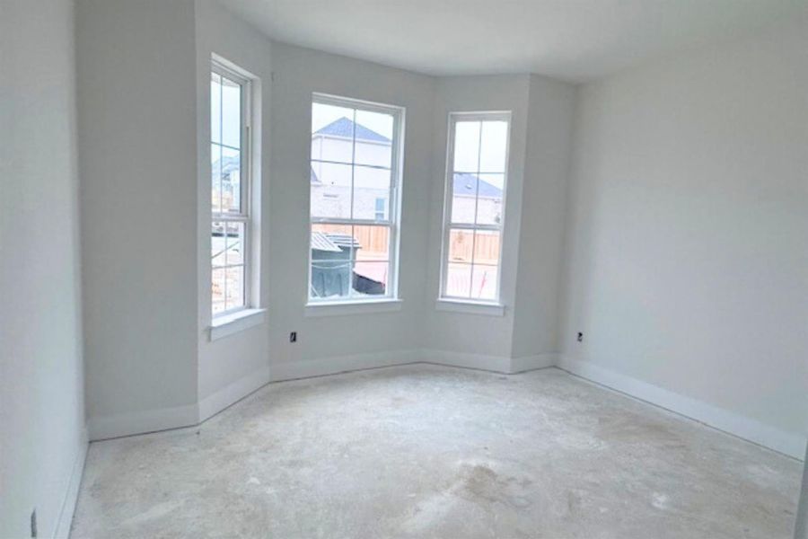 Unfurnished room featuring baseboards and unfinished concrete flooring
