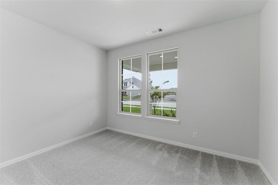 Two windows with white trim, light gray walls, and gray carpeted flooring