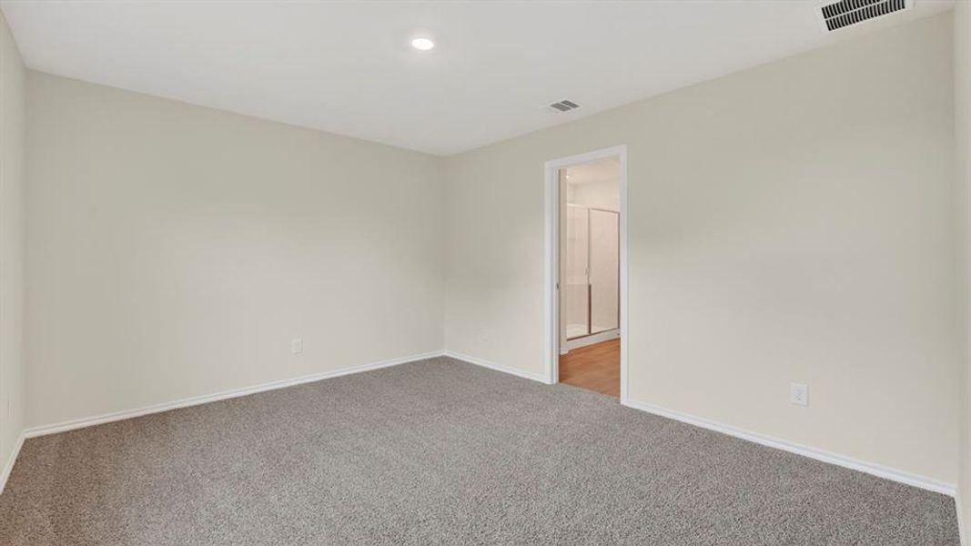 Spacious room featuring neutral carpeting, light-toned walls, recessed lighting, and white baseboards