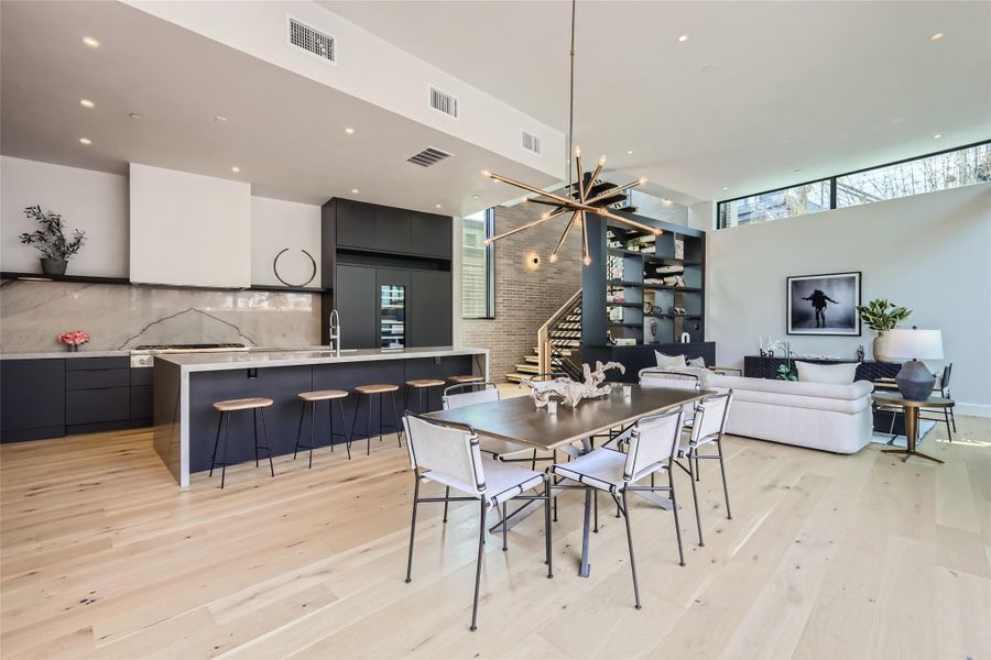 An open-concept living space with a sophisticated kitchen, a dining area, and a luminous living room. An open-concept living space with a sophisticated kitchen, a dining area, and a luminous living room.