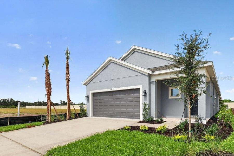 Front exterior of a new home in Indigo Creek, Apollo Beach, FL, highlighting curb appeal (Image 2). Front exterior of a new home in Indigo Creek, Apollo Beach, FL, highlighting curb appeal (Image 2).