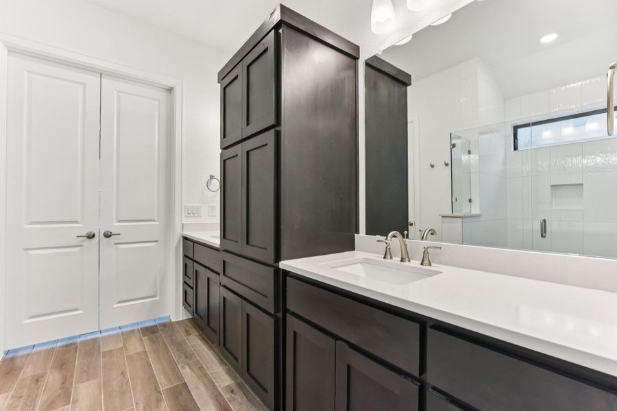 Bathroom featuring vanity, wood finish floors, and a shower stall Bathroom featuring vanity, wood finish floors, and a shower stall